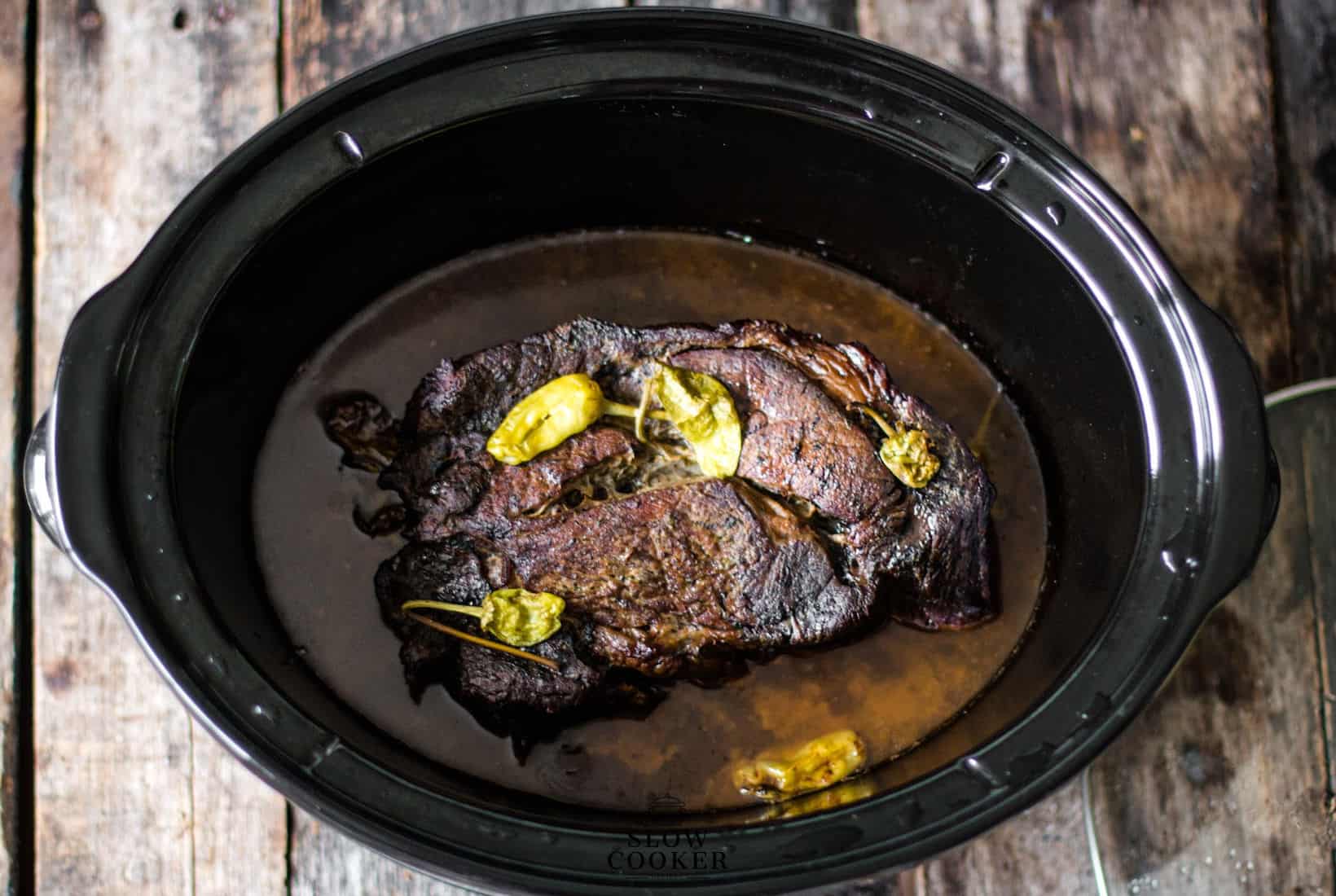 Slow Cooker Mississippi Pot Roast after the lid had been taken off, showing the juices and roast.
