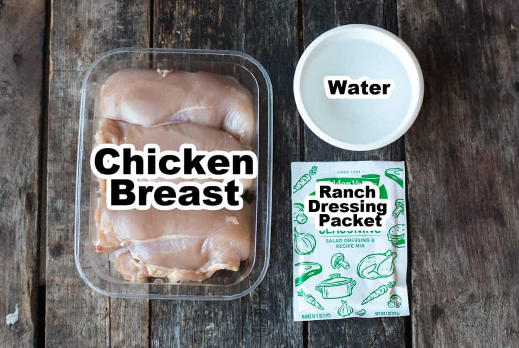 Slow Cooker Ranch Chicken ingredients on a wooden surface with text over each item labeling them. chicken breast. water. ranch dressing packet.