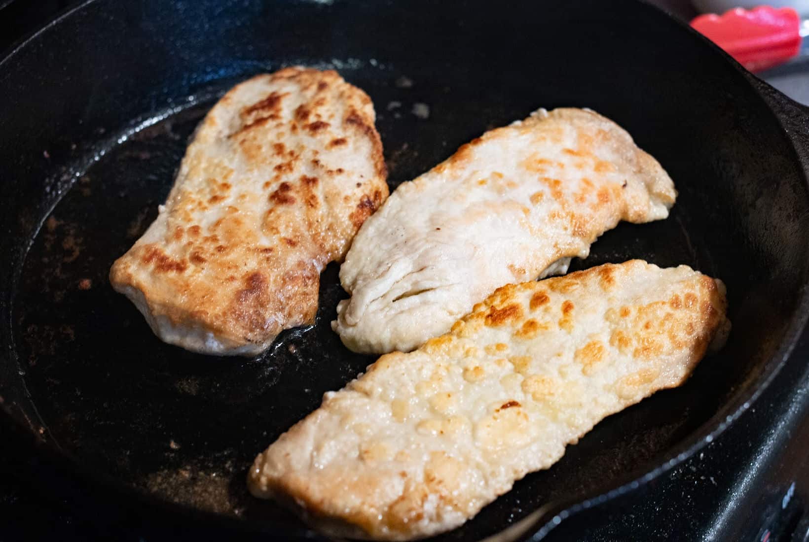 browned chicken breast in a cast iron pan.