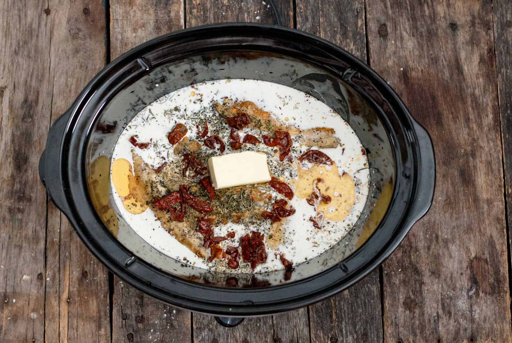 butter and sun dried tomatoes added to the slow cooker for Marry Me Chicken